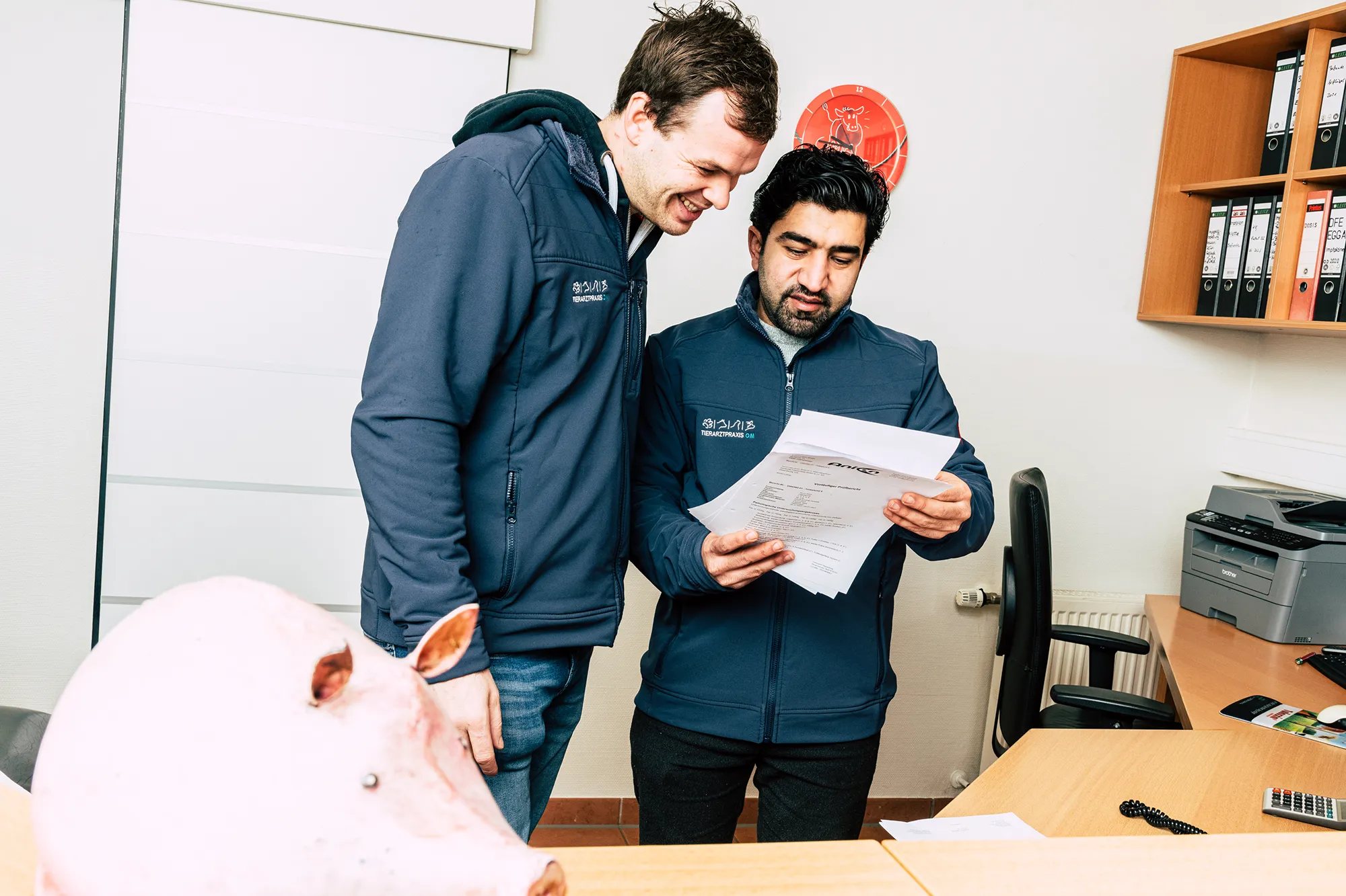 Zwei Teammitglieder der Tierarztpraxis OM besprechen im Büro über Unterlagen
